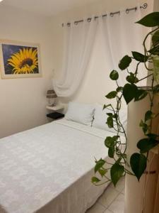sypialnia z białym łóżkiem i rośliną w obiekcie VILLA MONTESOLE w mieście Lecco