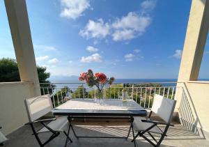 a table with a vase of flowers on a balcony at Solemar Sicilia - Villa delle Rocce in Bagheria