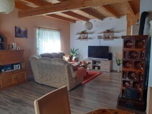 a living room with a couch and a television at Kuća za odmor Lika in Gospić