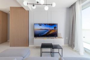 a living room with a flat screen tv on a wall at Seaview And Wellness Penthouse In Gozo - Happy Rentals in Xagħra