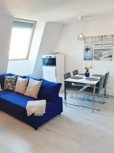 a living room with a blue couch and a table at Sunshine Residence Deluxe Apartment in Hévíz