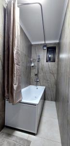 uma casa de banho com um lavatório branco e um chuveiro em Apartment in street Toktogula 77 em Bishkek