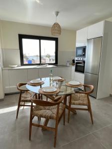 a kitchen with a table and chairs and a kitchen with a refrigerator at Arena Sunrise - Sea View and Main Street in Corralejo