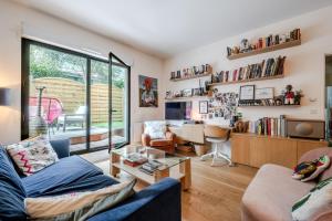 uma sala de estar com um sofá e uma mesa em Veeve - Tranquility Terrace em Boulogne-Billancourt