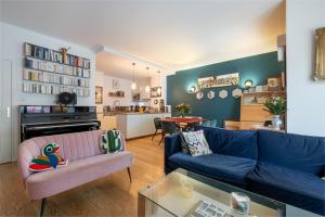uma sala de estar com um sofá azul e uma mesa em Veeve - Tranquility Terrace em Boulogne-Billancourt