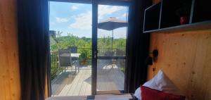 Schlafzimmer mit Blick auf einen Balkon mit Sonnenschirm in der Unterkunft GLÜCK HOMES Baumhaus in Ippesheim