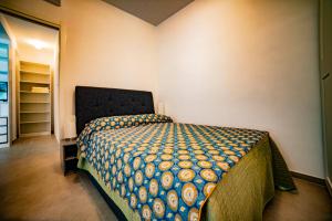 um quarto com uma cama com um edredão colorido em WHITE VEIO LODGE em Roma
