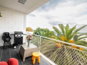 a balcony with a grill and some palm trees at Lovely 3 Bedroom Unit Sandton in Johannesburg