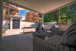 eine Terrasse mit Korbstühlen und einem Tisch in der Unterkunft WHITE VEIO LODGE in Rom