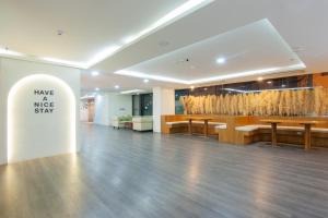 a lobby with wooden tables and a sign that says have a nice stay at Golden Jomtien Beach Hotel in Jomtien Beach