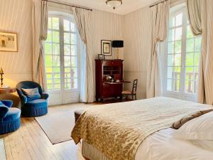 Un dormitorio con una cama, un escritorio y ventanas. en Villa du Châtelet, en Choisy-au-Bac