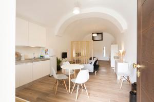 eine Küche und ein Wohnzimmer mit einem Tisch und Stühlen in der Unterkunft Qu4ttro I Domus47 Pompei in Pompei
