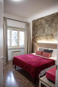 ローマにあるDomus Coriolanoのベッドルーム1室(赤毛布付きの大型ベッド1台付)