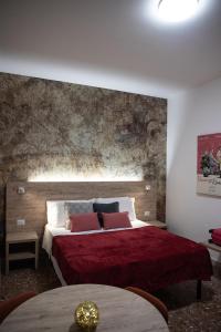 ローマにあるDomus Coriolanoのベッドルーム1室(赤いシーツと枕の大型ベッド1台付)