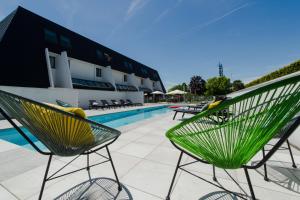 two green chairs sitting next to a swimming pool at ibis budget Toulouse Labège in Labège