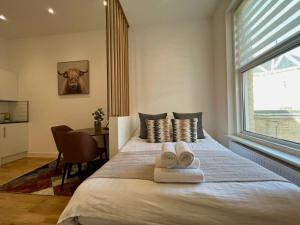 a bedroom with a large bed with towels on it at 208, The Kové, West Hill Road in Bournemouth