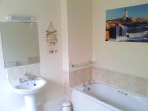 a bathroom with a sink and a toilet and a bath tub at Yew Tree House in Paignton
