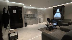 a living room with a couch and a table and a kitchen at Lagona Serviced Apartments in Al Ahsa