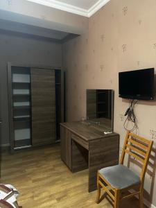 a room with a desk and a chair and a television at Hotel Nirvana in Tbilisi City