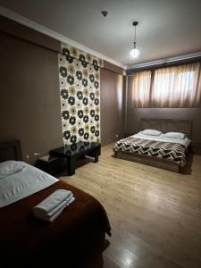 1 dormitorio con 2 camas y pared de flores en Hotel Nirvana, en Tiflis