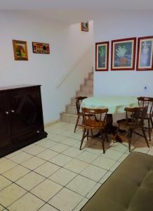 a room with a table and chairs and a fireplace at Duplex Encantador in Guarapari