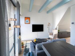 a living room with a blue couch and a tv at 2 modern apartments in the heart of Sneek in Sneek