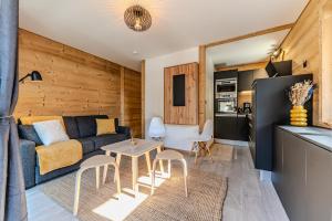 ein Wohnzimmer mit Sofa und Tisch in der Unterkunft Appartement La Terrasse de Roma - LES GETS, en plein centre et au pied des pistes in Les Gets