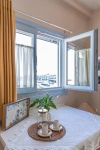 a table with two cups and a plant on a table with two windows at Manus Dei Exclusive Suites in Pythagoreio