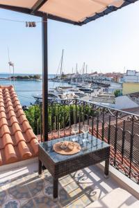 balcone con tavolo e vista sul porto turistico di Manus Dei Exclusive Suites a Pythagóreion