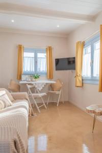 Manus Dei Exclusive Suites في بيثاغوريو: غرفة معيشة مع أريكة وطاولة
