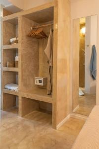 a walk in closet with wooden shelves and a mirror at Manus Dei Exclusive Suites in Pythagoreio