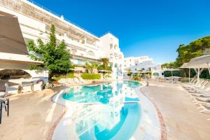 a swimming pool at a hotel with white buildings at Hotel Cala Dor - Adults Only in Cala d´Or
