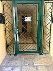 a green door with a dog inside of it at Residence Le due Corti in Imola