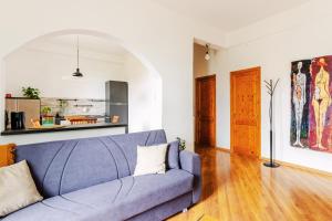 ein Wohnzimmer mit einem blauen Sofa und Holzböden in der Unterkunft [Mare - Ciclabile] Giardino e Parcheggio gratuito in Sanremo + 22 Fotos