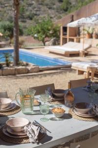 a table with plates and bowls on it next to a pool at Villa Can Rasca in Caimari