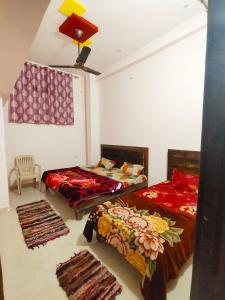 two beds in a room with two rugs at Deviksha Home Stay in Ujjain