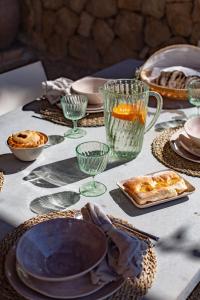 una mesa con platos y vasos y comida en ella en Villa Can Rasca en Caimari