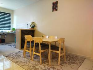 a dining room with a table and four chairs at Axaida Homestay Parit Jawa in Bakar Parit