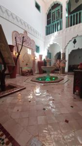 une chambre avec une fontaine au milieu d'un bâtiment dans l'établissement Riad Mille Et Une Nuits, à Marrakech