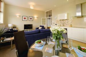 - un salon avec une table et un canapé bleu dans l'établissement Beachcomber - Aldeburgh Coastal Cottages, à Aldeburgh