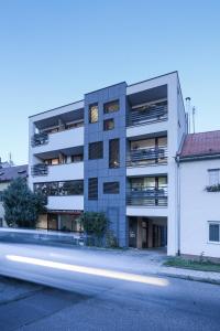 an apartment building with a car speeding past it at Pár pokojů microhotel in Zlín