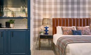 a bedroom with a bed and a table with a lamp at The Tophams Hotel in London