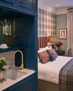 a blue bedroom with a bed and a sink at The Tophams Hotel in London