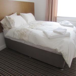łóżko z białą pościelą i poduszkami w obiekcie Lord Nelson Hotel w mieście Rhymney
