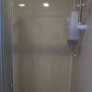 a shower in a bathroom with a phone on the wall at Lord Nelson Hotel in Rhymney