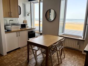 阿罗芒什莱班À l'est - Studio vue mer sur la digue的配有桌椅的厨房,享有海滩美景