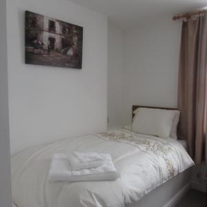 Una cama blanca con dos toallas encima. en Lord Nelson Hotel, en Rhymney