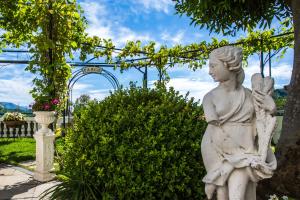 a statue of a woman sitting in a garden at Hotel Scapolatiello in Cava deʼ Tirreni