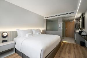 a large white bed in a hotel room at Maison Hotel Bangkok in Bangkok