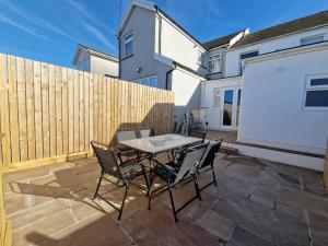 a patio with a table and chairs and a fence at 3 Bedroom Stylish Home Merthyr in Merthyr Tydfil